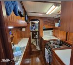 galley kitchen with microwave, stove, sink